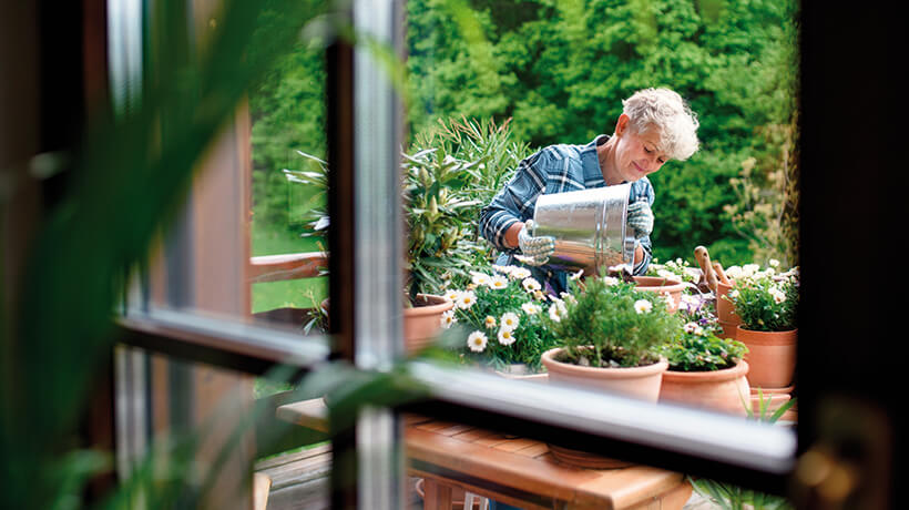 A woman potting plants on her garden table