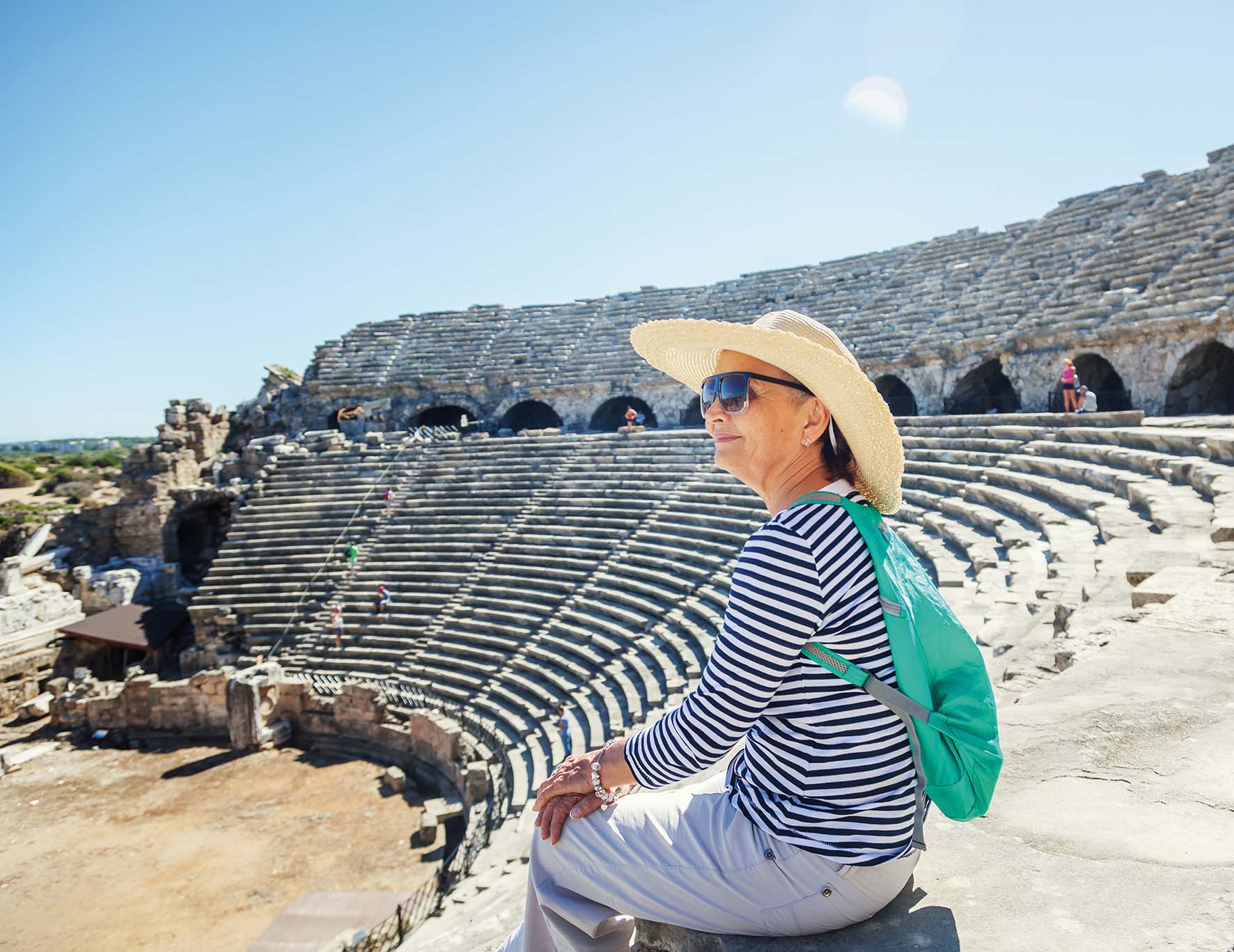 An older woman visiting a Greek amphitheatre