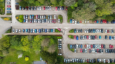 A variety of different cars parked in a woodland car park