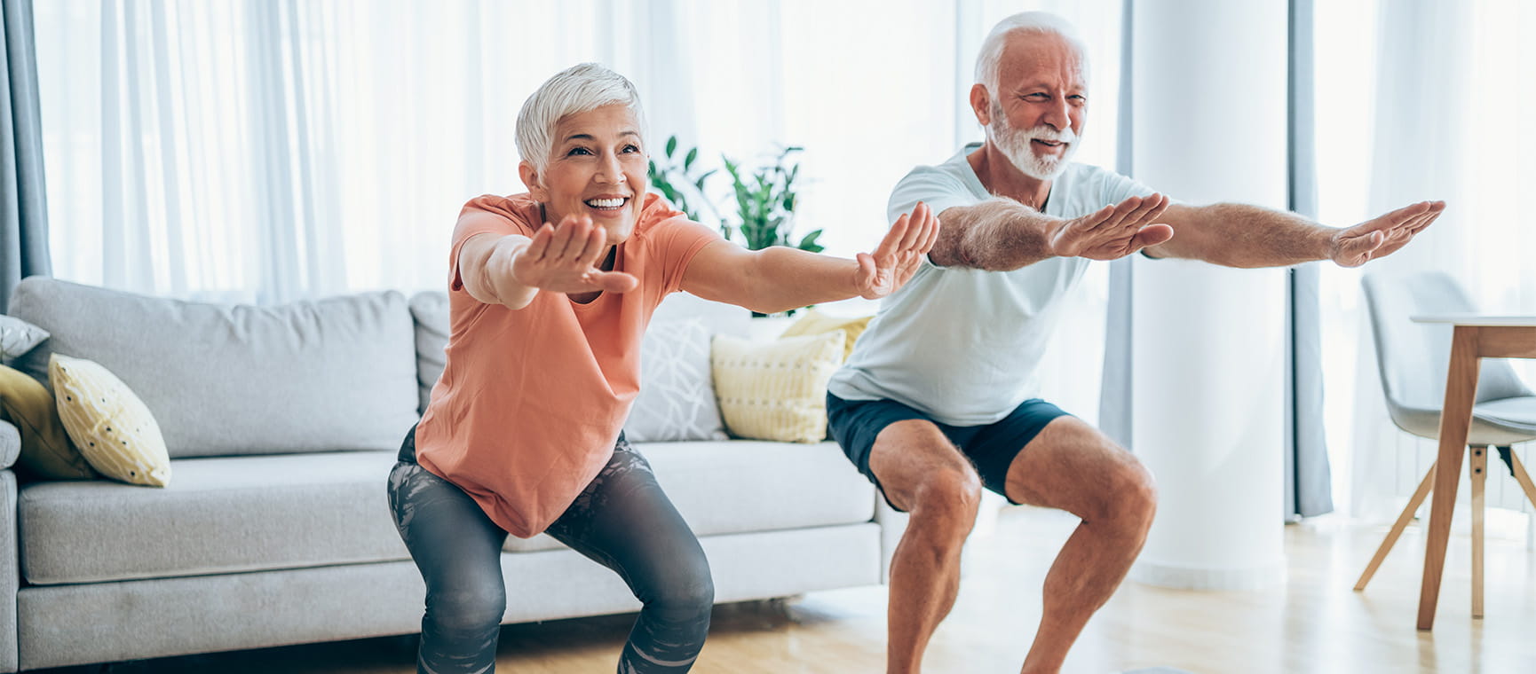 An older couple doing squats