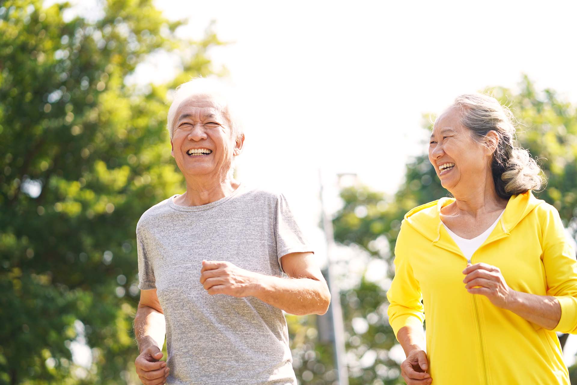 A man and woman running outdoors looking happy