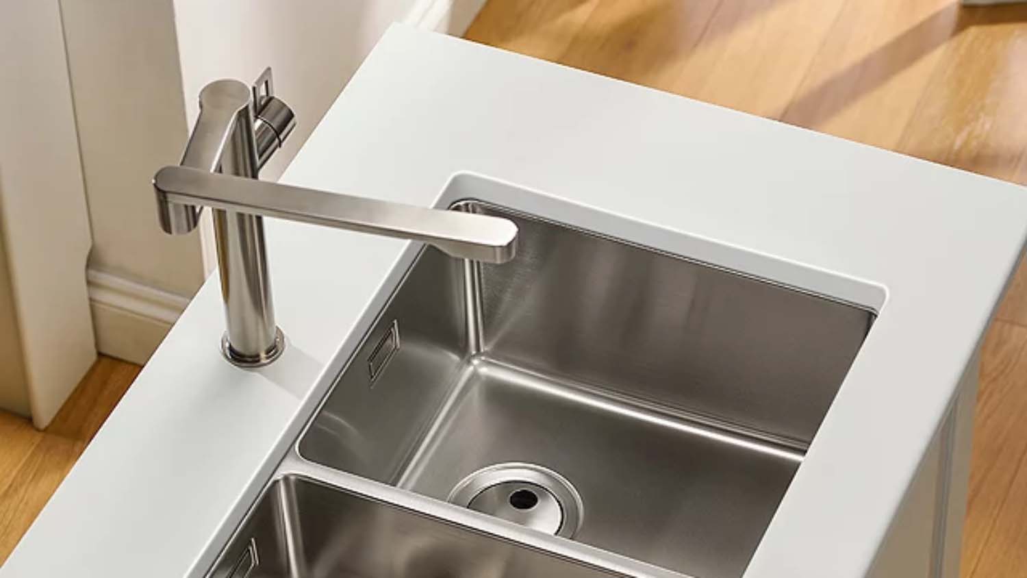Close-up of a chrome sink and tap set into a countertop.
