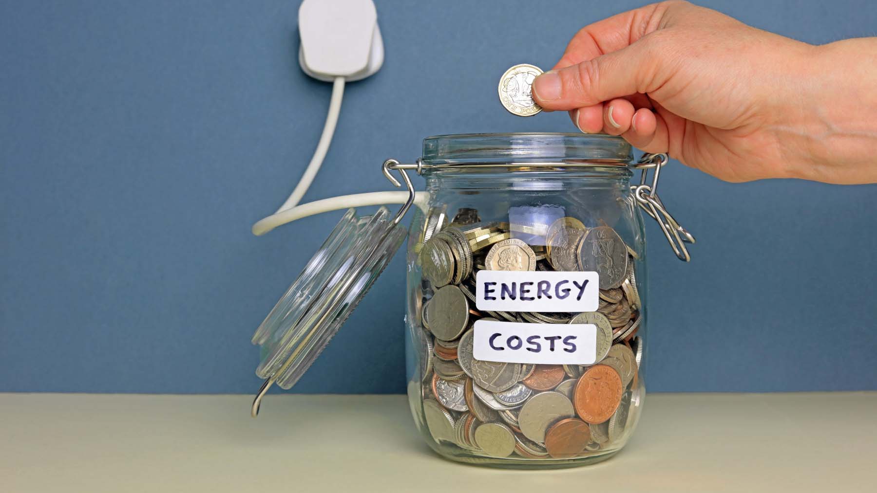 jar with coins in and a label saying energy costs on it