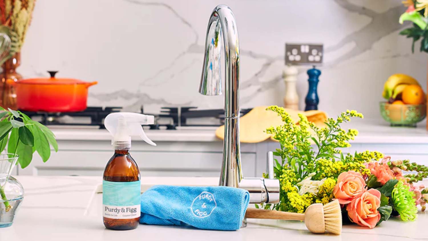 A kitchen island with a sink and tap, eco-friendly hand soap and a bouquet of flowers