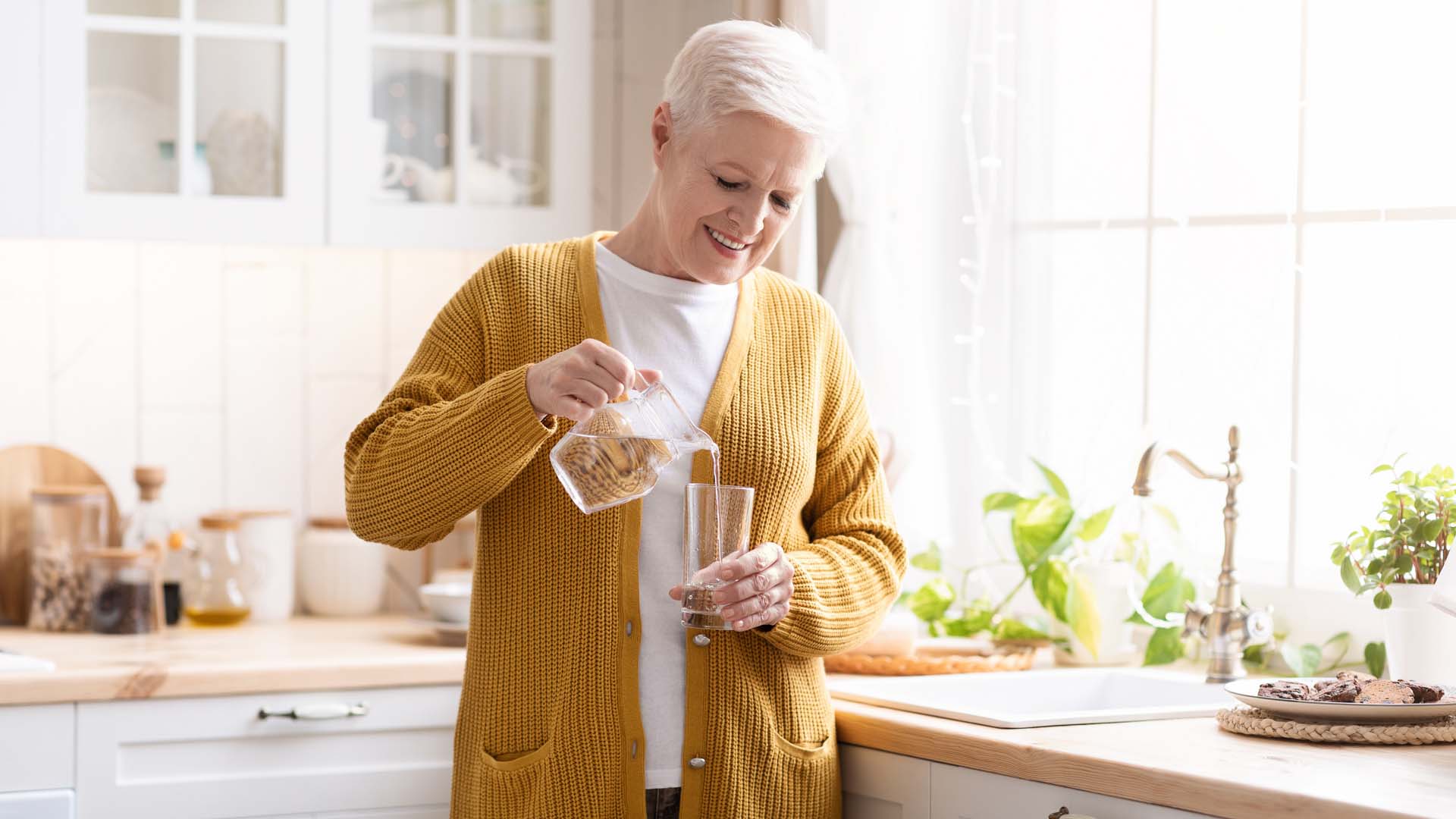 woman in the kitchen pouring a glass of water