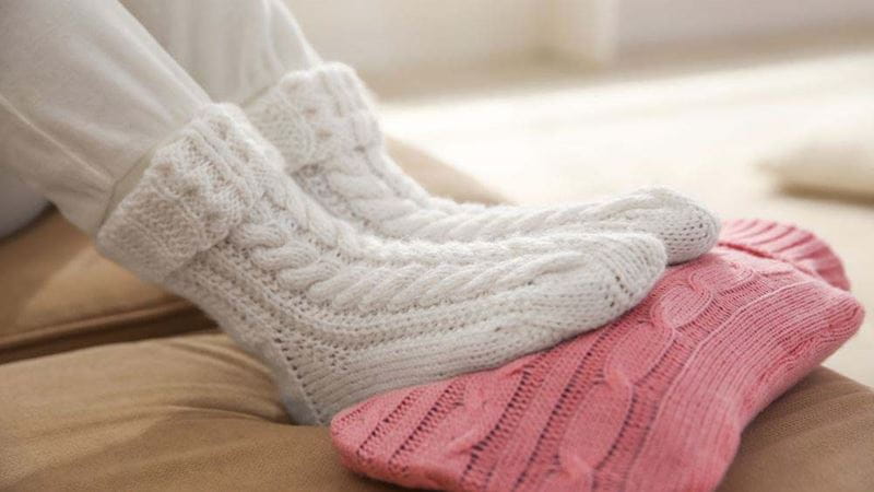 Feet in cosy socks on a wool covered hot water bottle