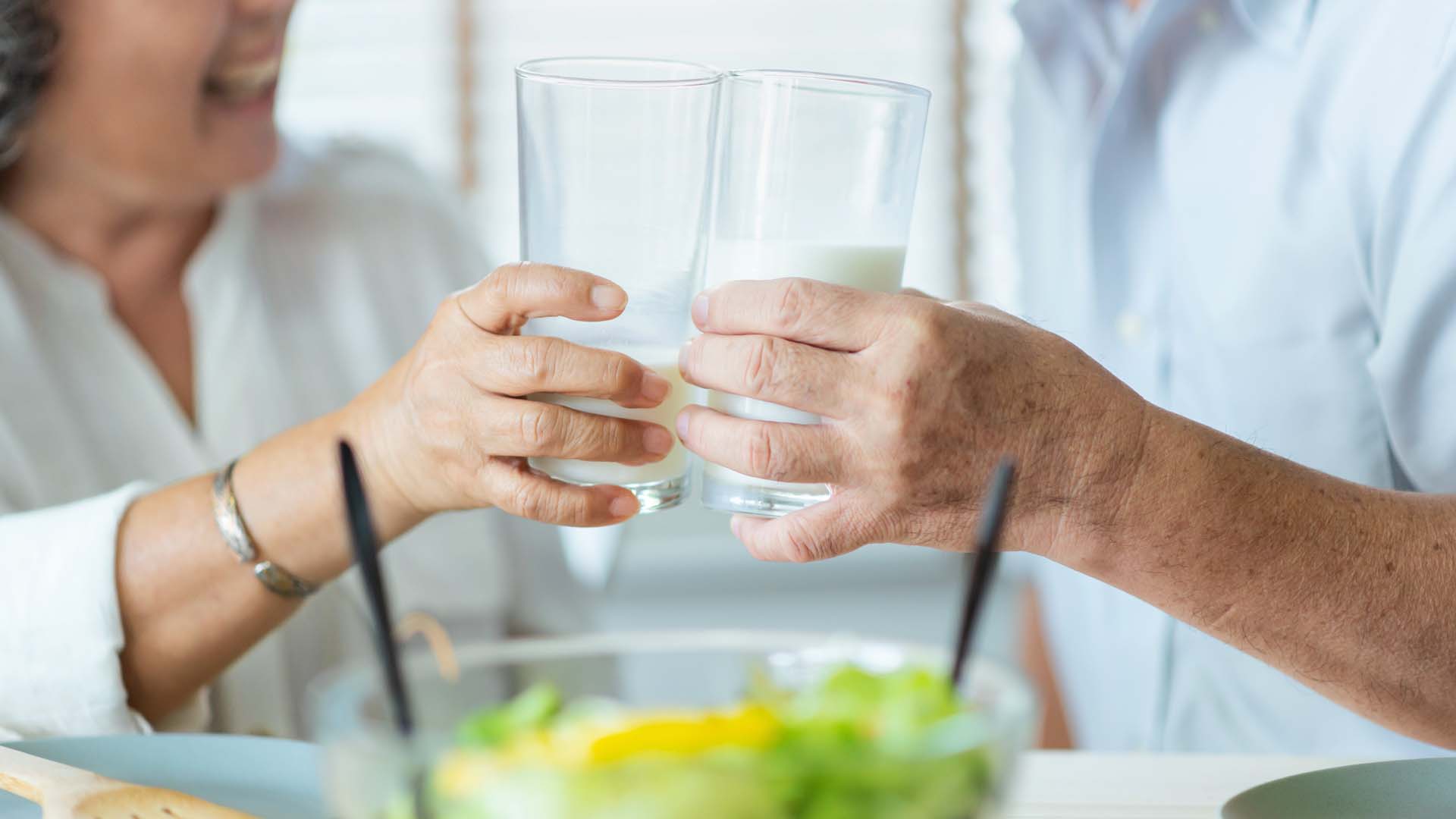 people clinking two glasses of milk