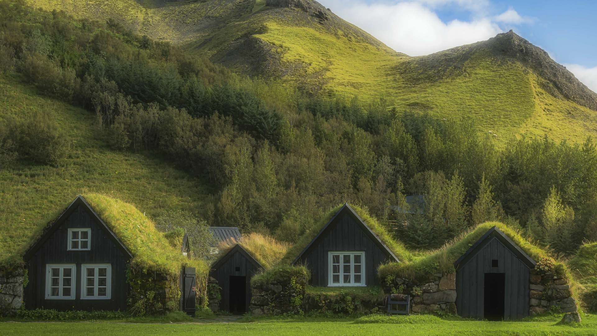 model turf houses, historically recreated at Skógar Museum in Iceland, which look like houses born from the earth