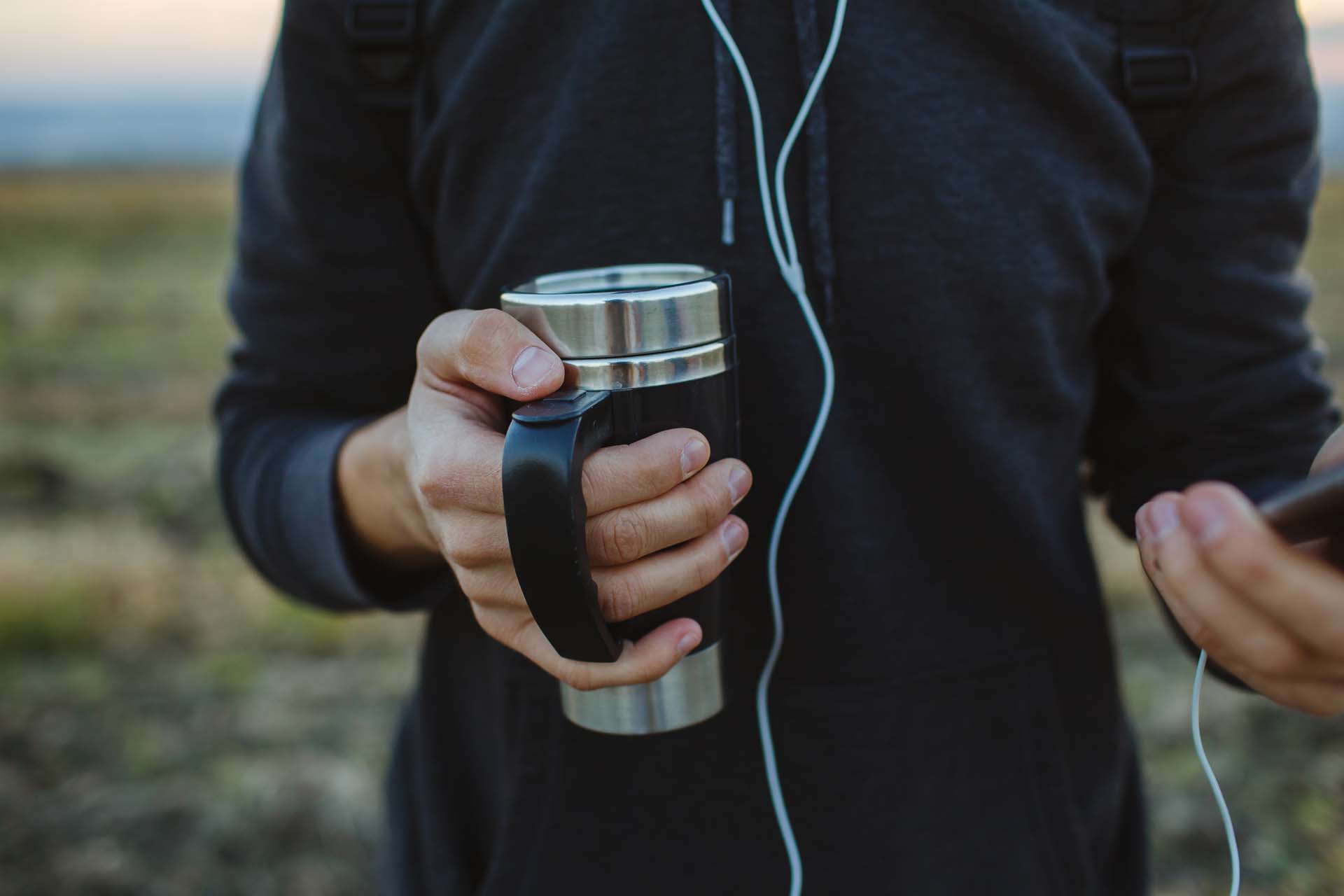 A person holding a thermos cup