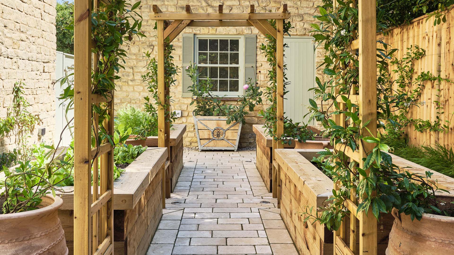 a trellis covered walkway with planters either side