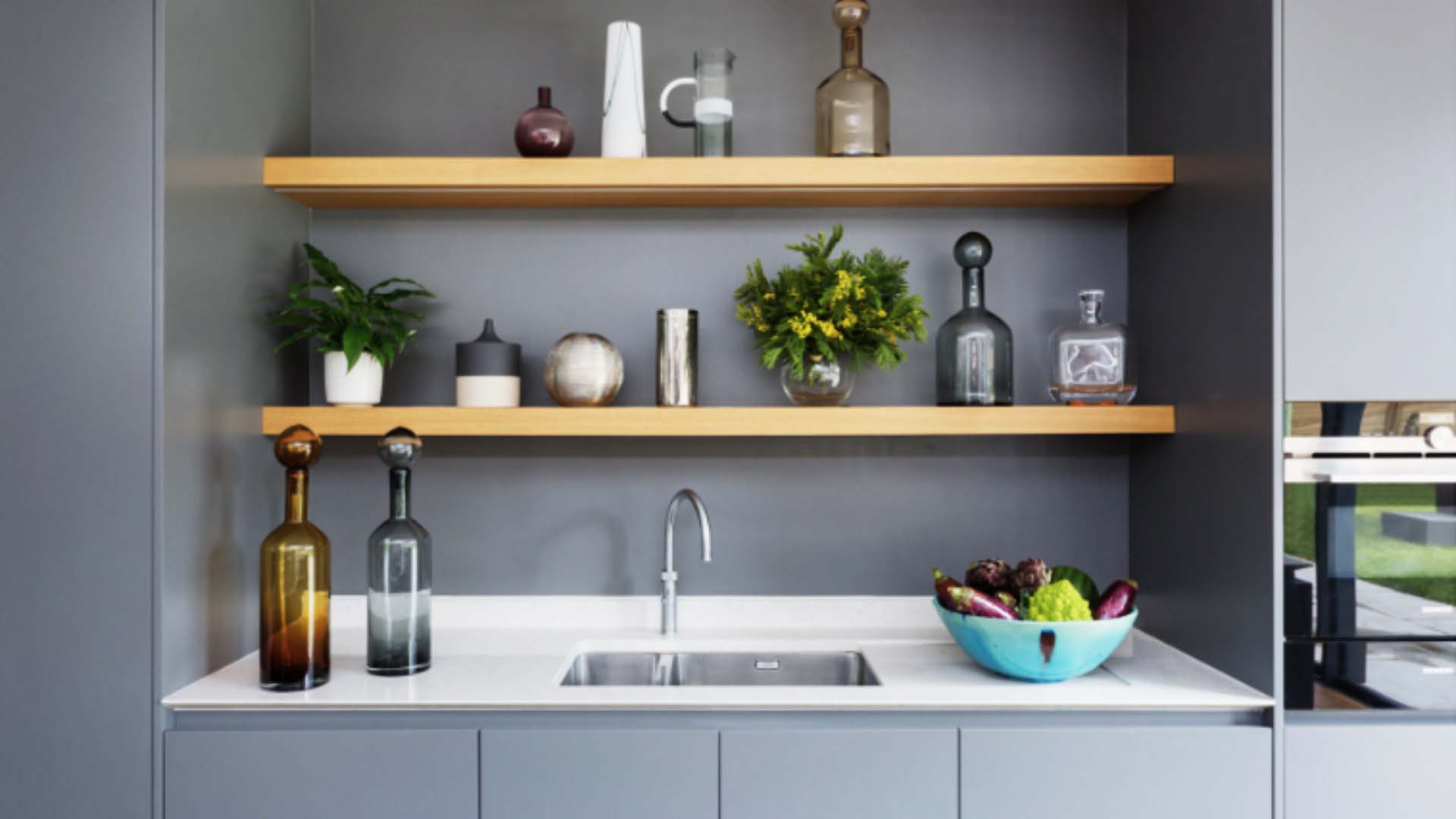 This kitchen by Hux uses limited space above the sink for shelves which are purely dedicated to decorative vases and plants