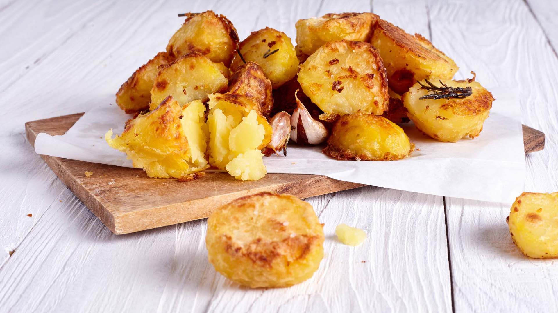 Well cooked roast potatoes on a chopping board