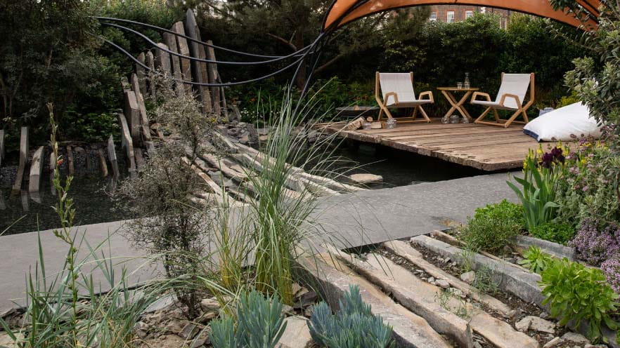 Coastal rocks inspired rockery with pond and two sun loungers