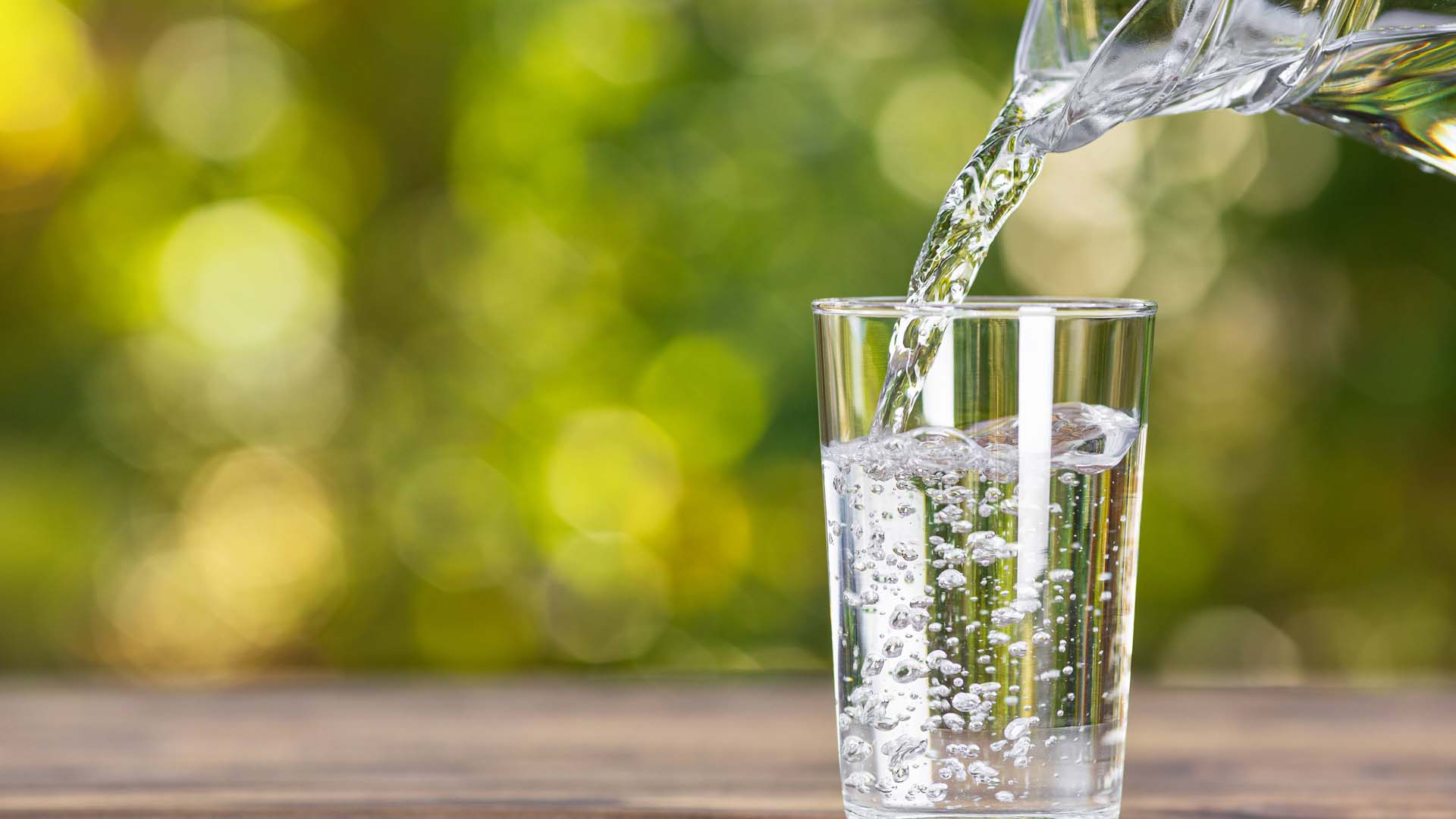 Close-up of a jug pouring water into a glass.