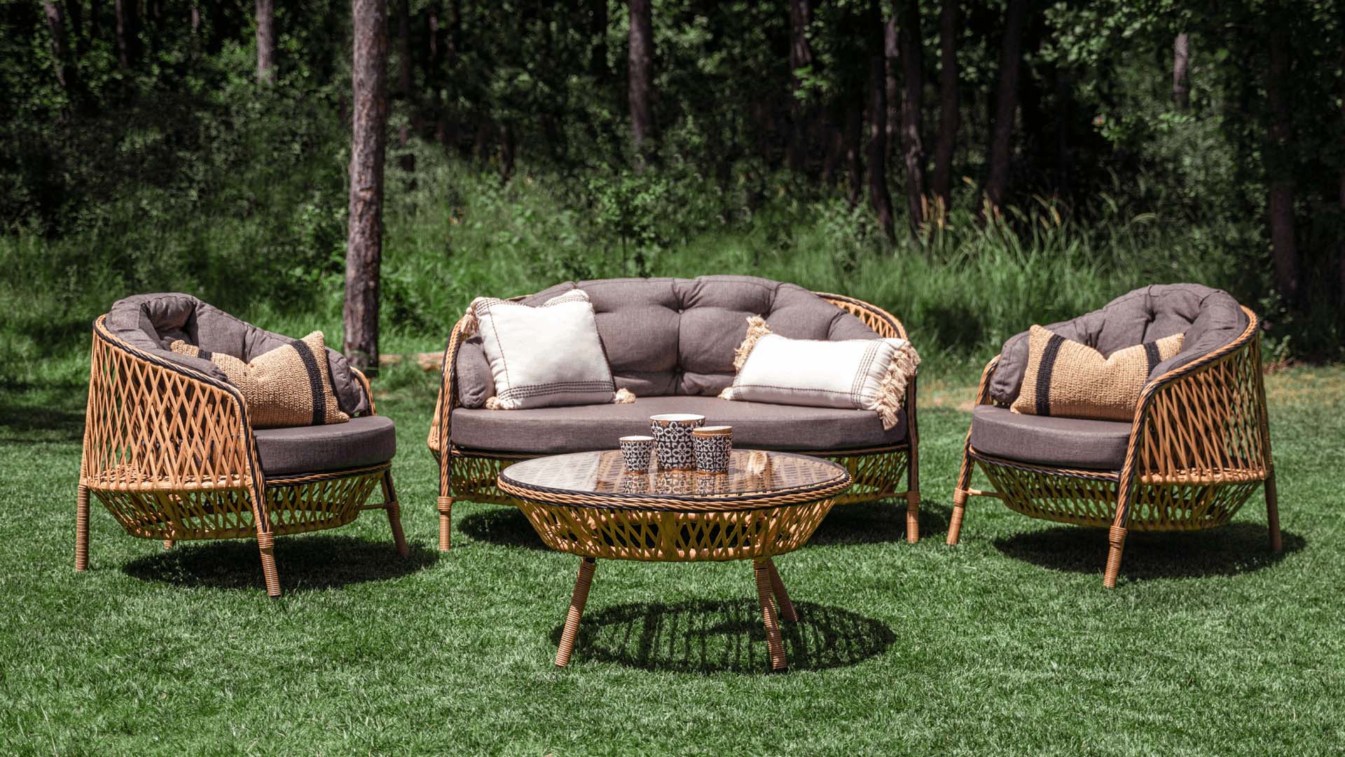 Garden furniture set in the grass, made from Rattan with comfortable cushions