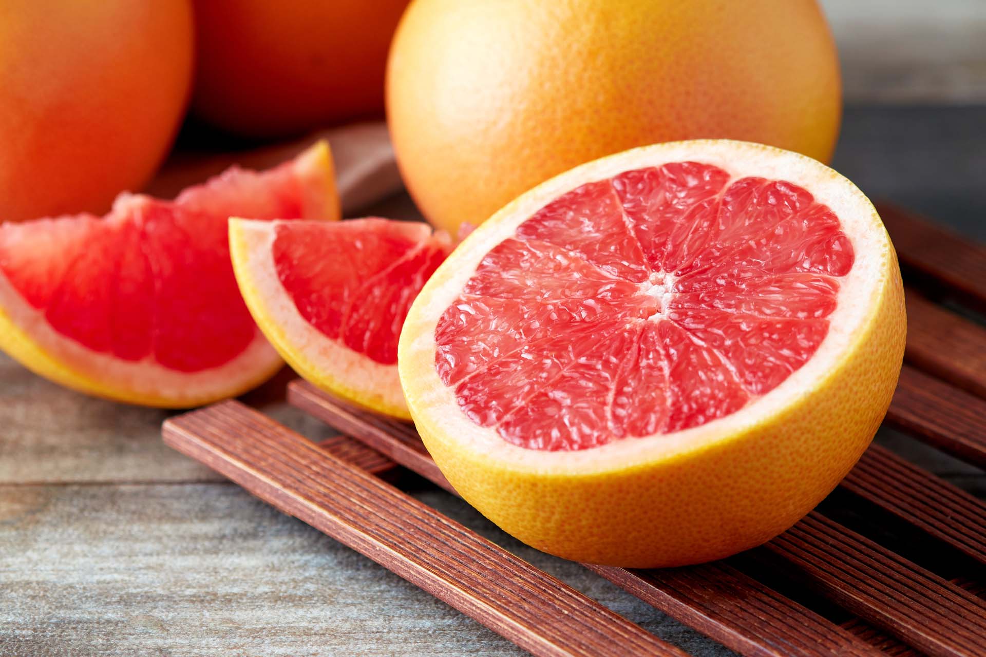Fresh raw grapefruit (citrus x paradisi) cut on wooden background