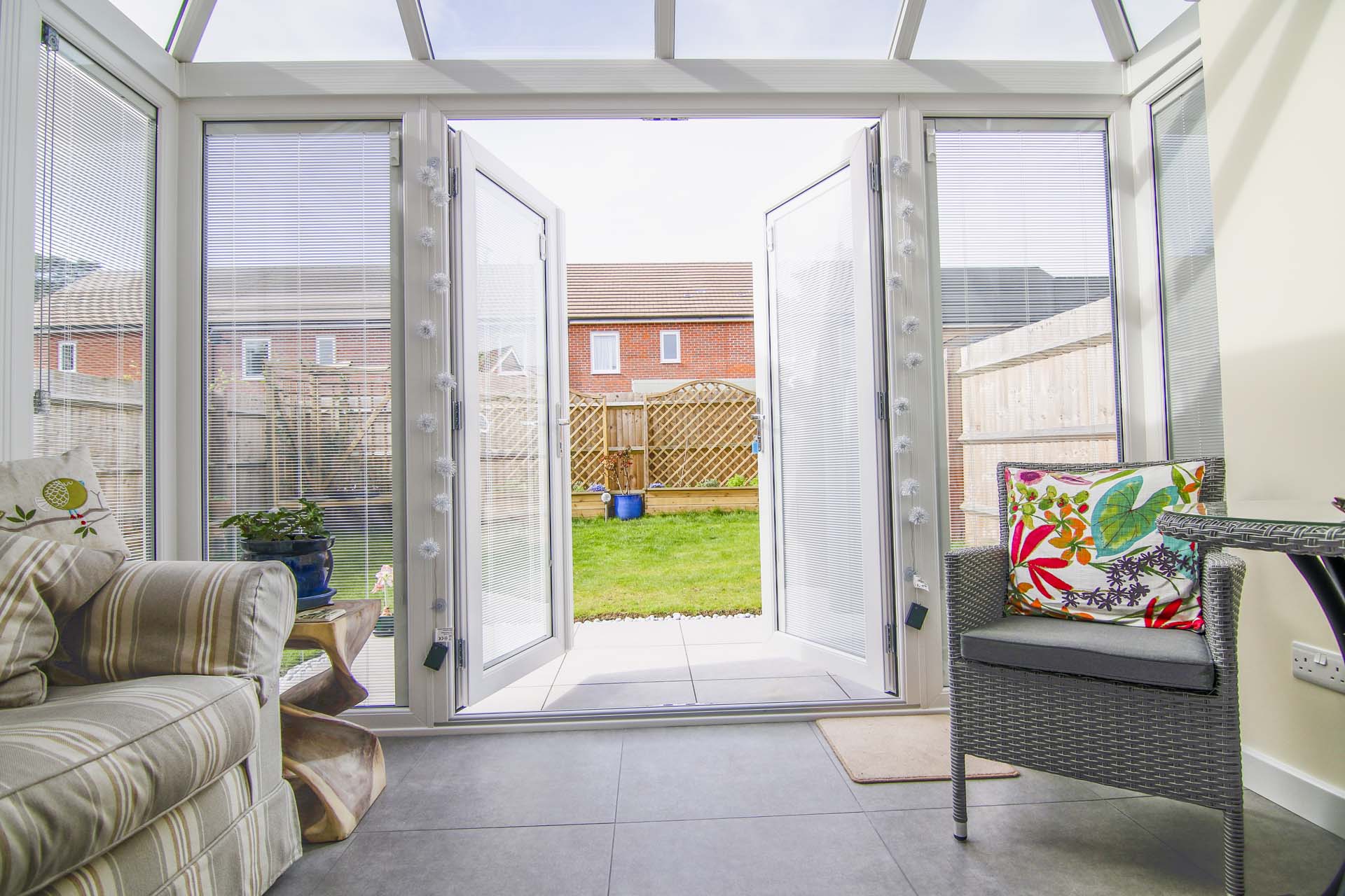 A conservatory with wide open French doors