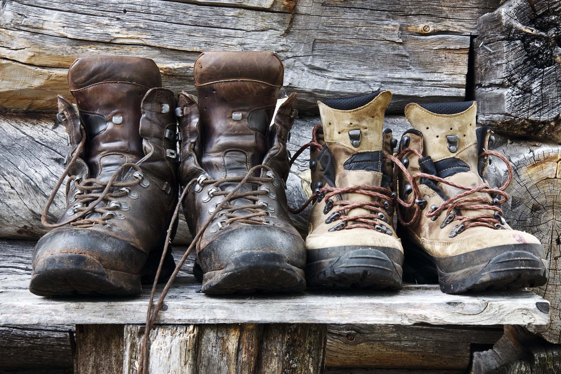 Two pairs of muddy hiking boots in different sizes