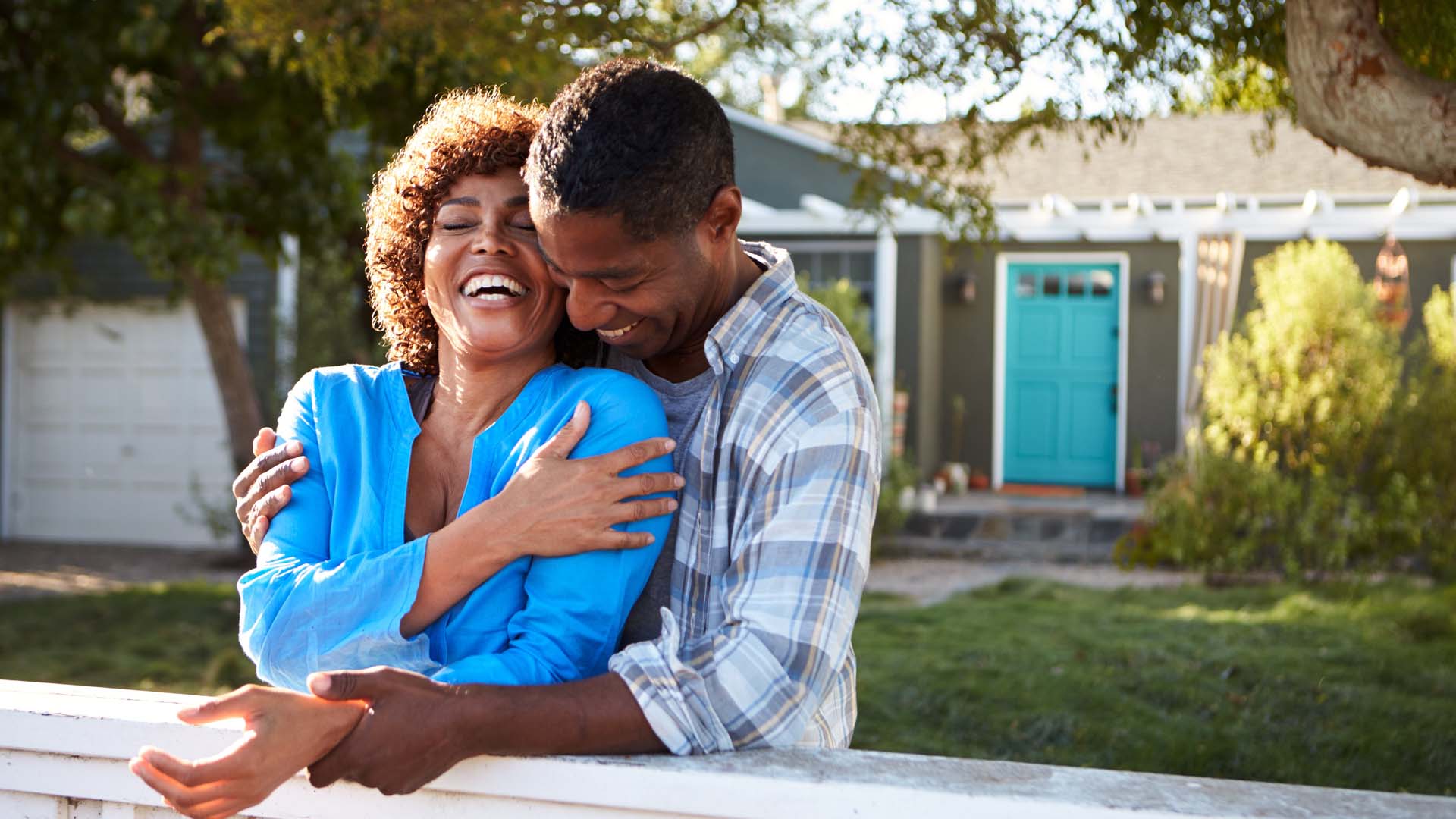 Couple hugging outside house