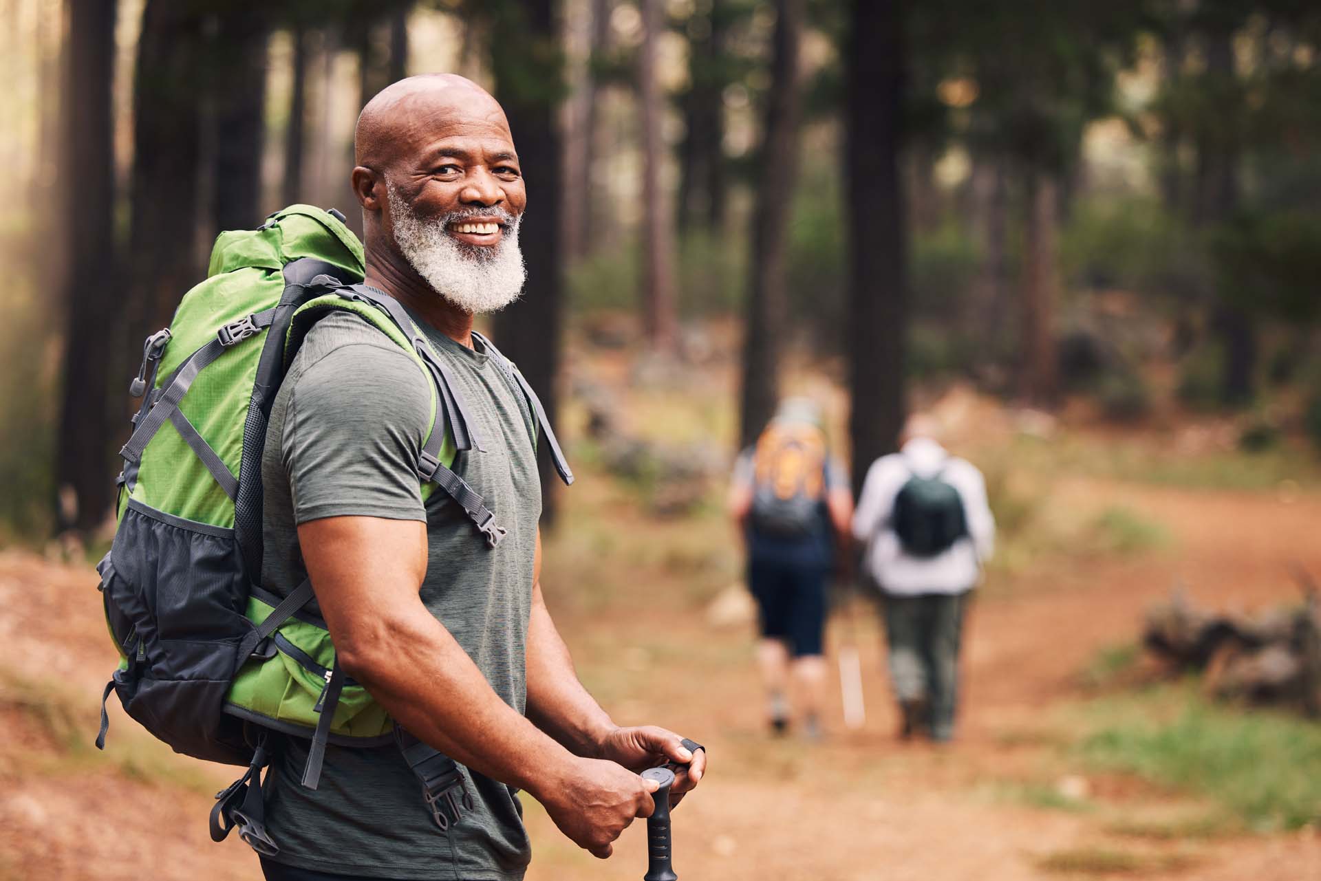 An older man posing for a photo whilst hiking