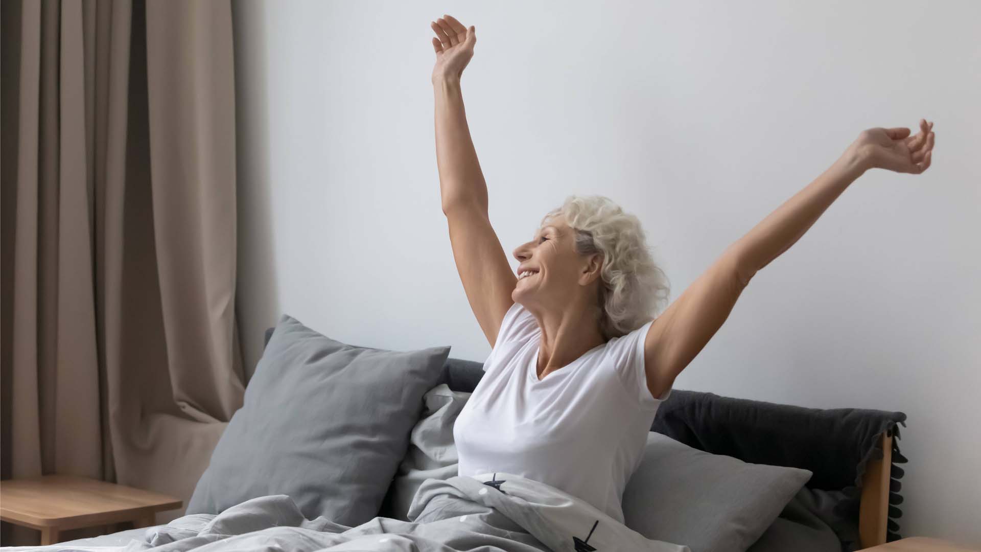 Lady awake stretching her arms up in bed after going to sleep fast
