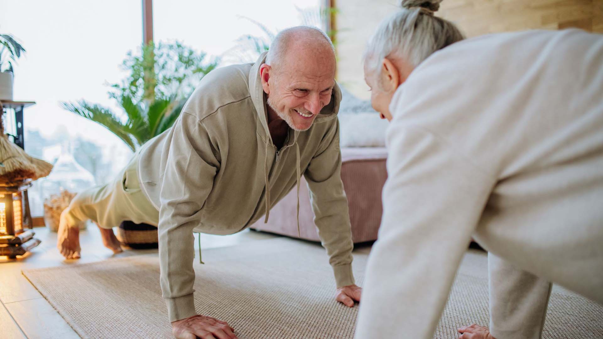 An older couple exercising at home