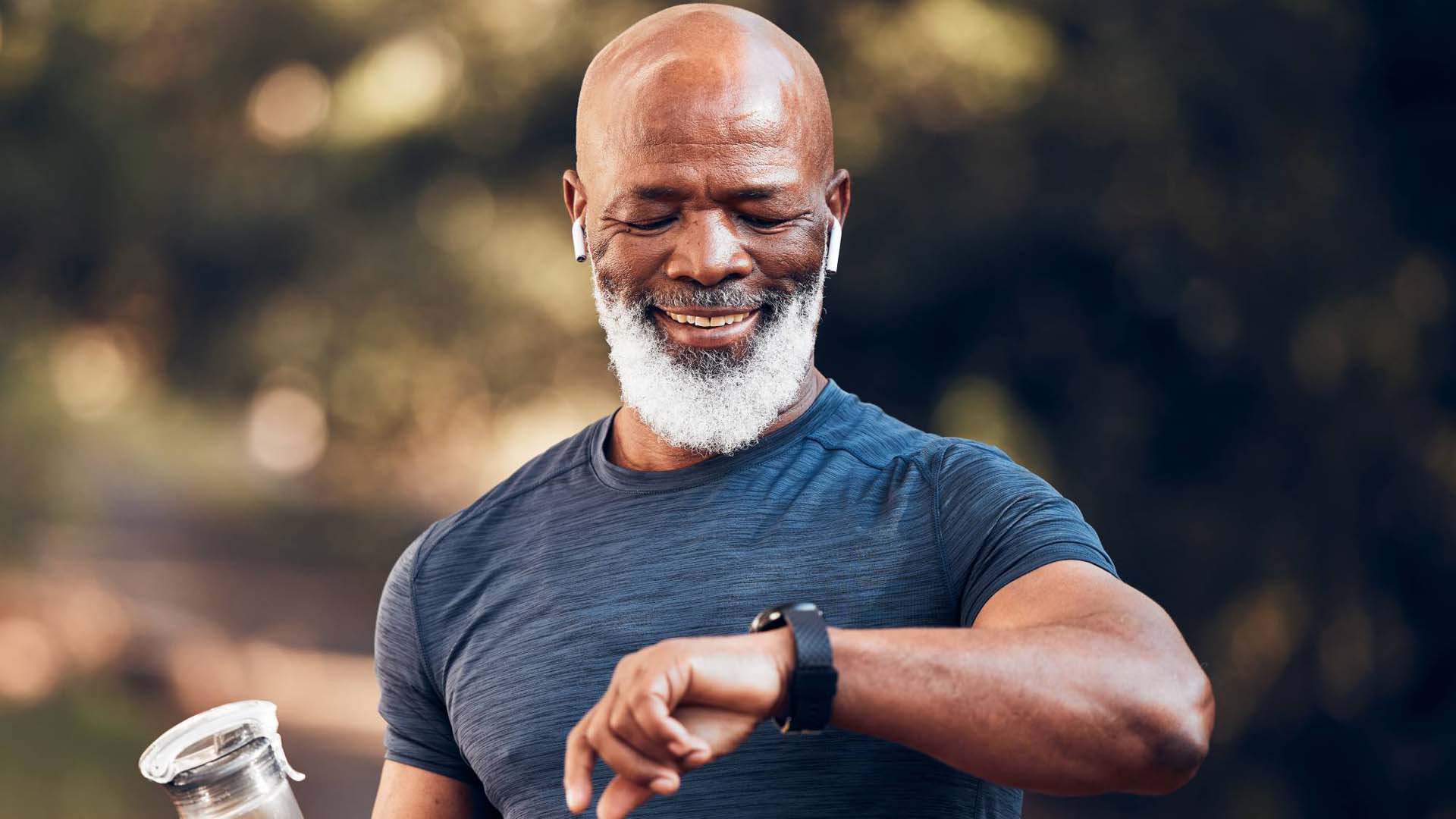 Man with a water bottle checking his fitness watch