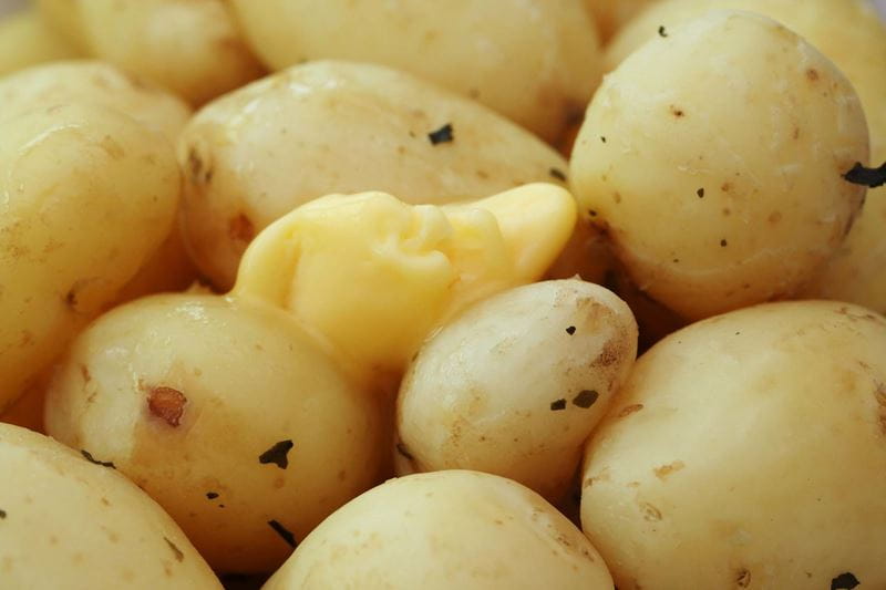 Cooked potatoes with a knob of butter melting in the middle
