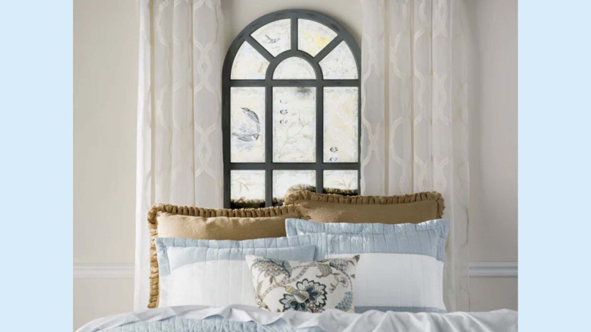A pretty window behind a bed