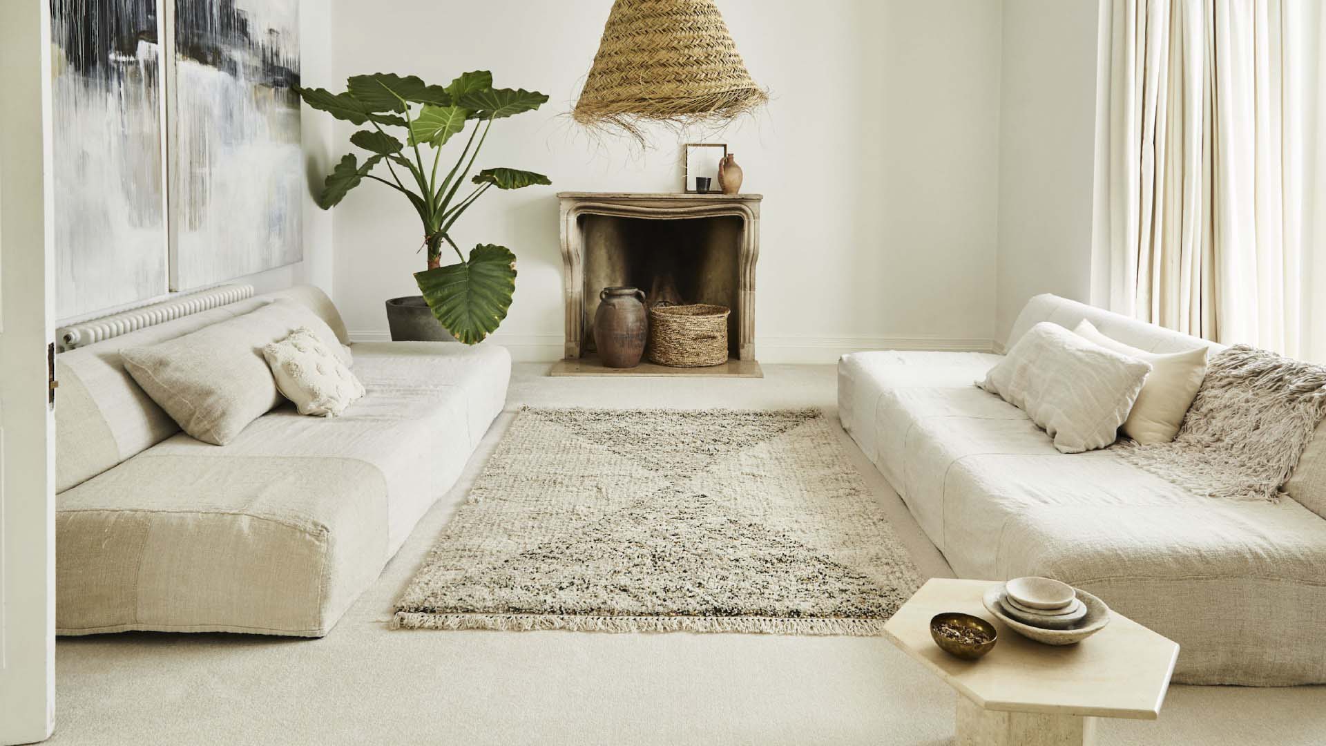 A cream themes living room with a large central rug