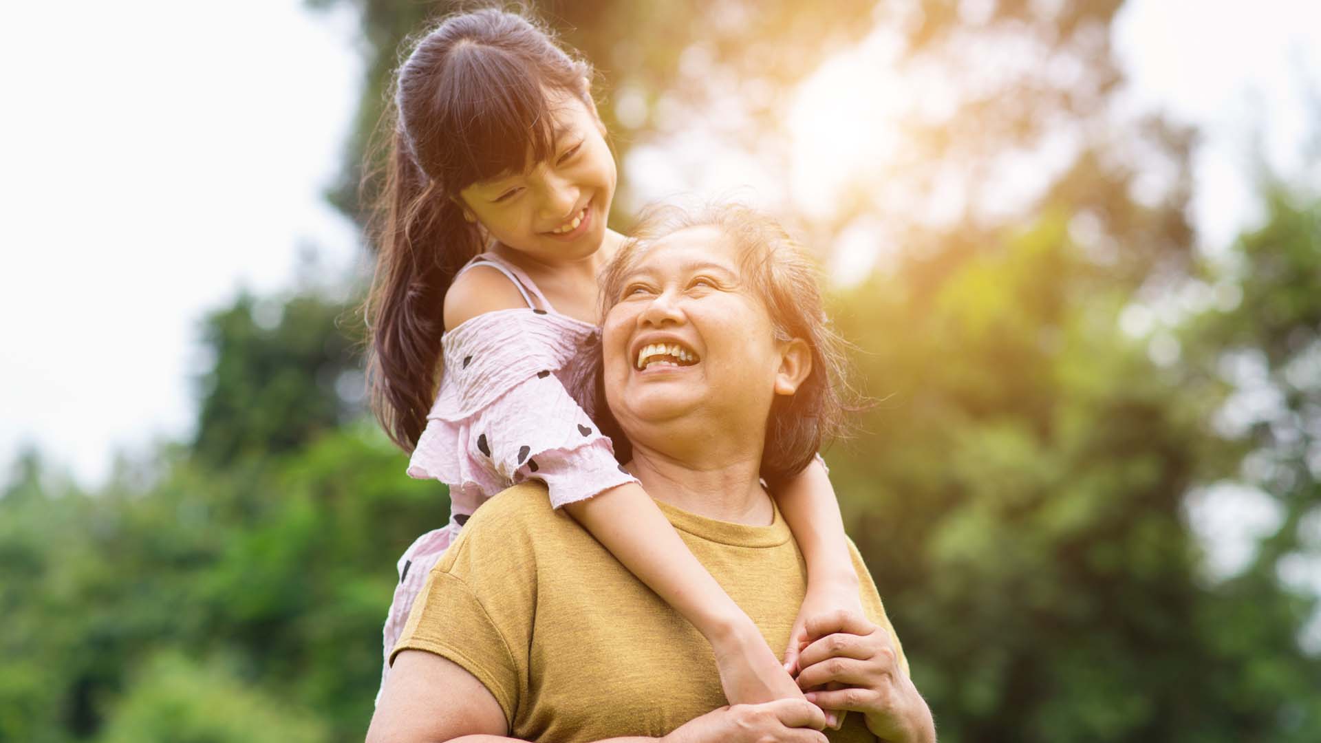Grandmother and grandchild smiling and happy in the sun