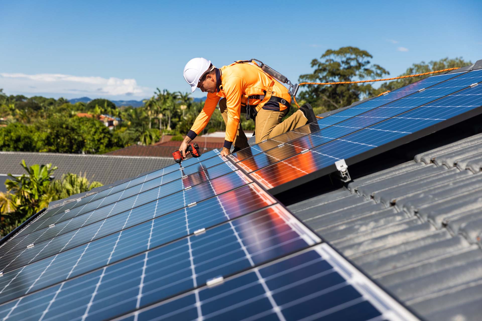 An expert installing solar panels on the roof of a house