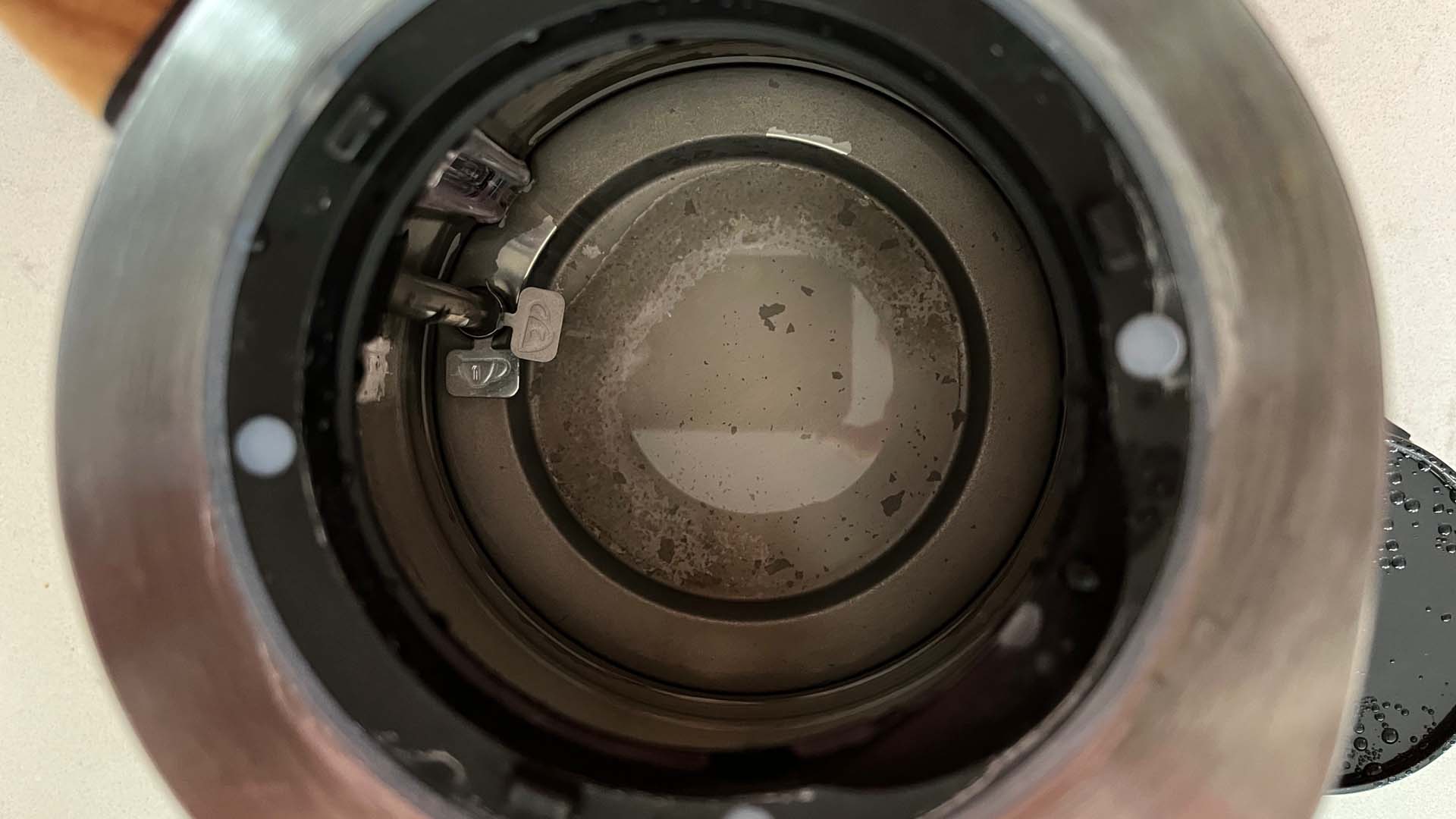 The inside of a kettle covered in limescale