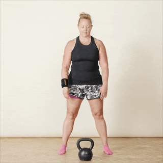 A woman in sports clothing demonstrating kettlebell swings