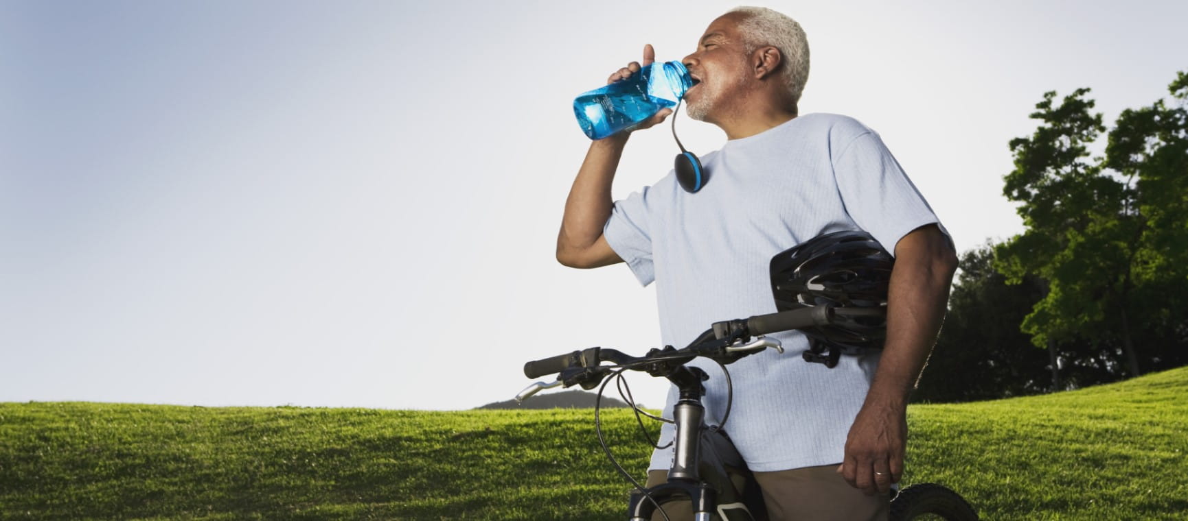 A man with  water bottle and mountain bike ensuring he stays hydrated during exercise | Getty/Jupiterimages