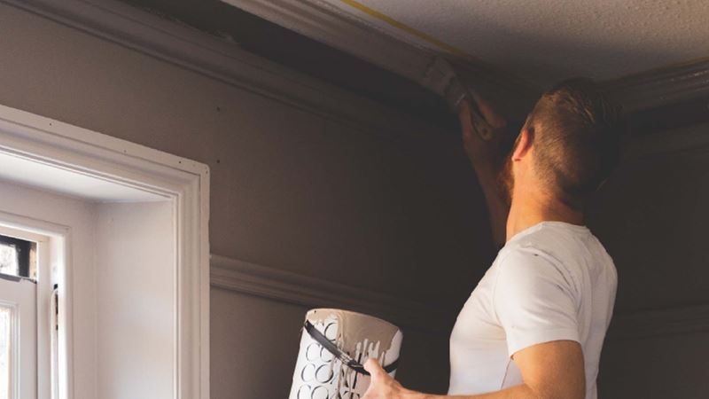 man painting wall corners