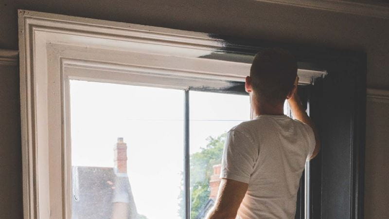 Man painting window frame