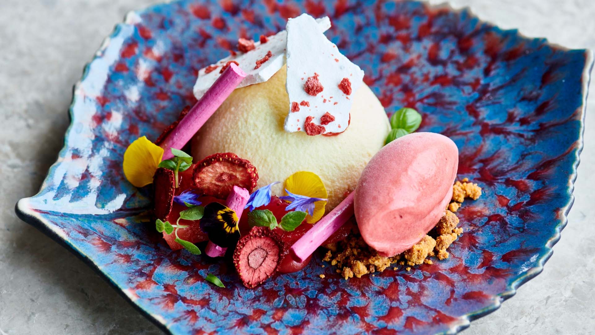 A colourful parfait on a blue leaf-shaped plate
