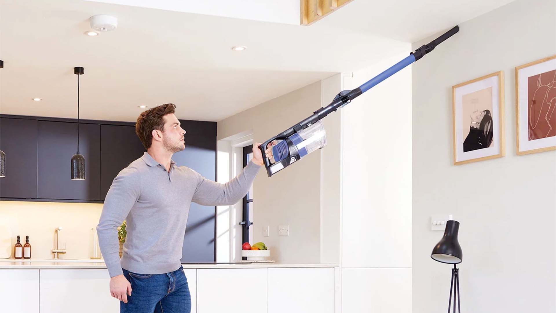 man vacuuming the lounge ceiling