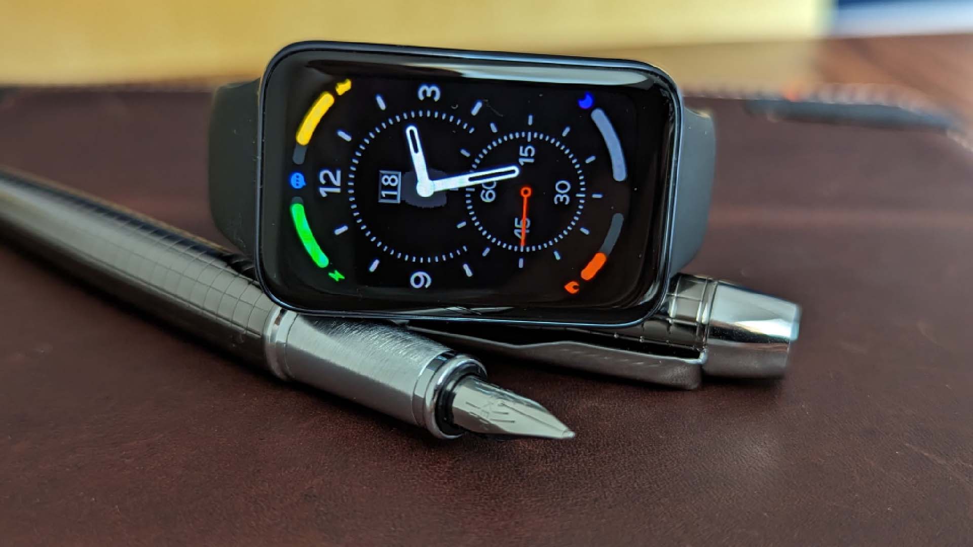 A fitness tracker with digital display showing daily activity stats