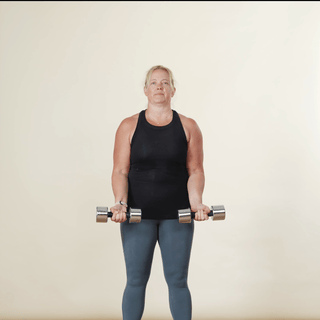 Woman performing a bicep curl to overhead press with dumbbells