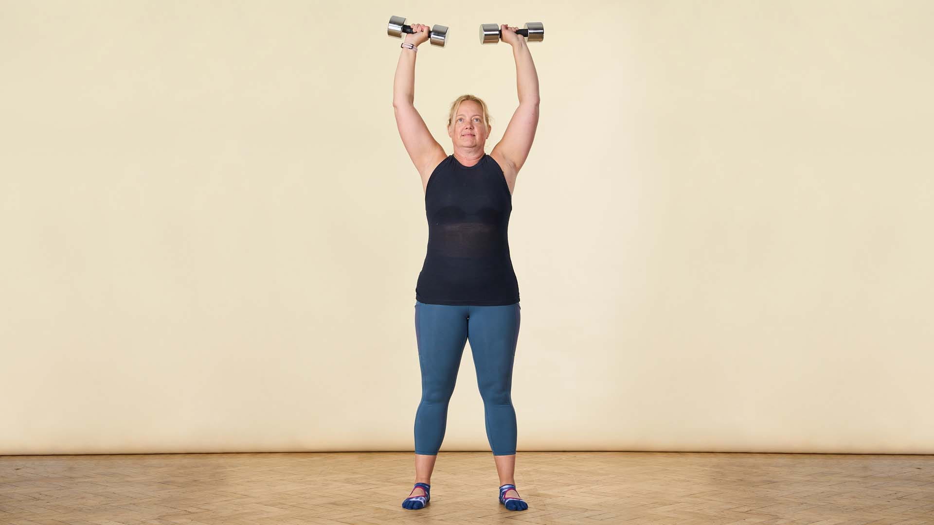 woman holding dumbells up