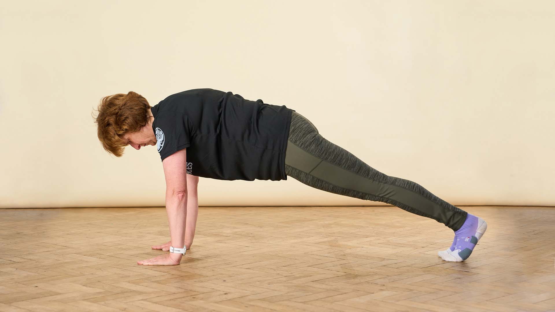 A woman in sports attire demonstrating a plank position