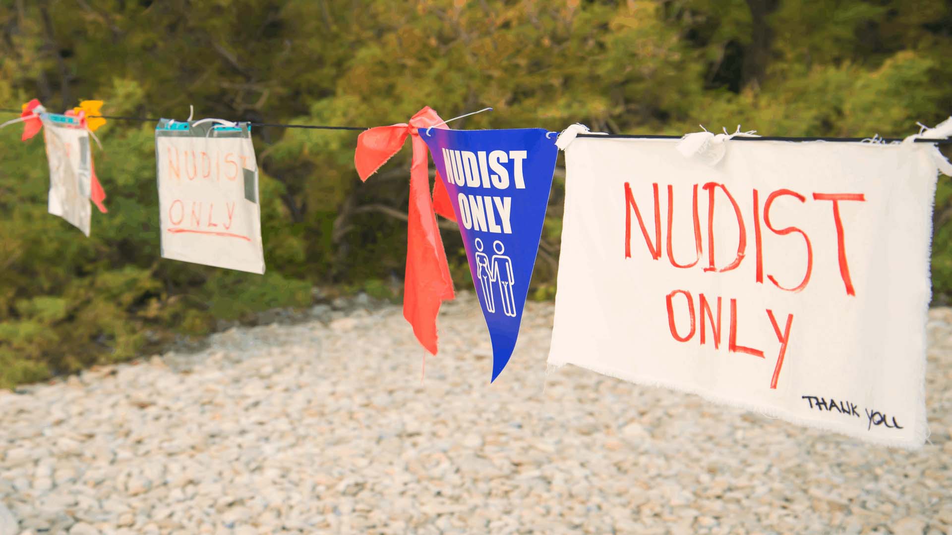 Bunting and signs signposting 'NUDIST ONLY'