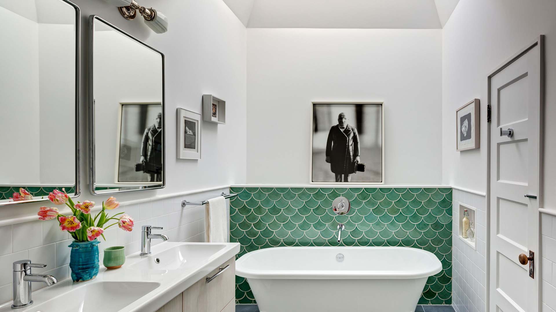 A bright bathroom with green feature tiling over the bathtub