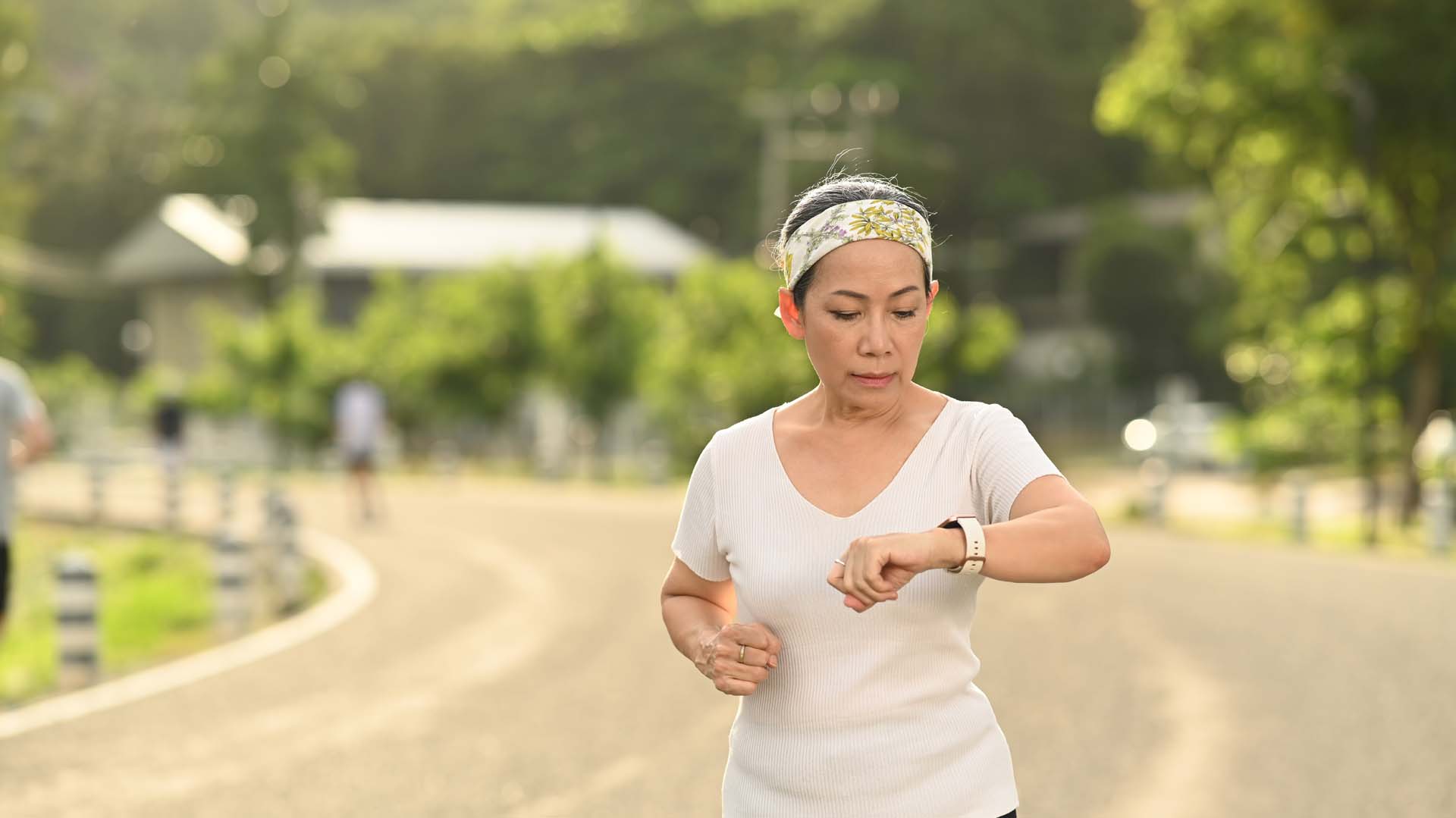 A woman checks her watch during a run