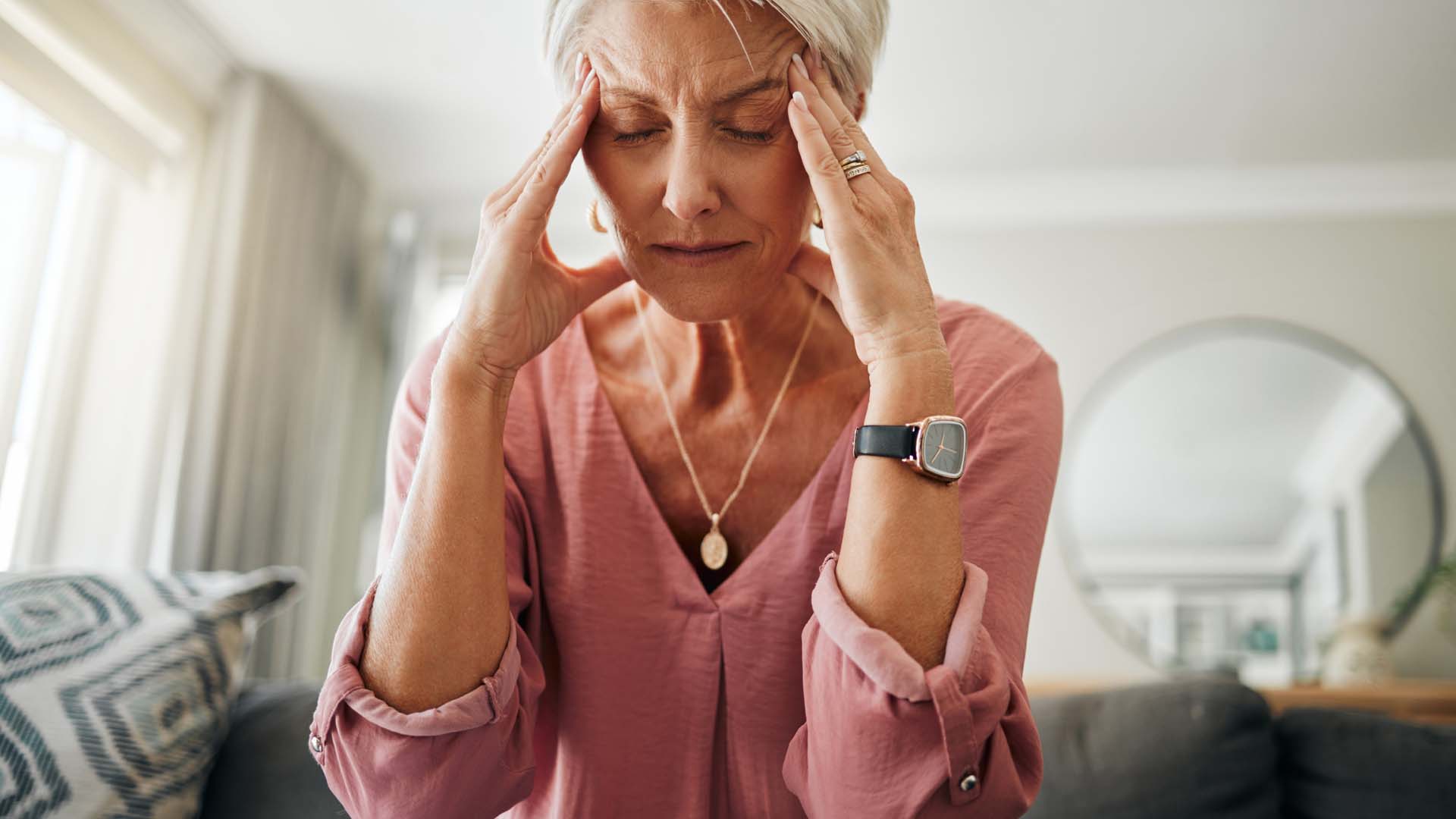 woman sitting on the edge of the bed head in her hands