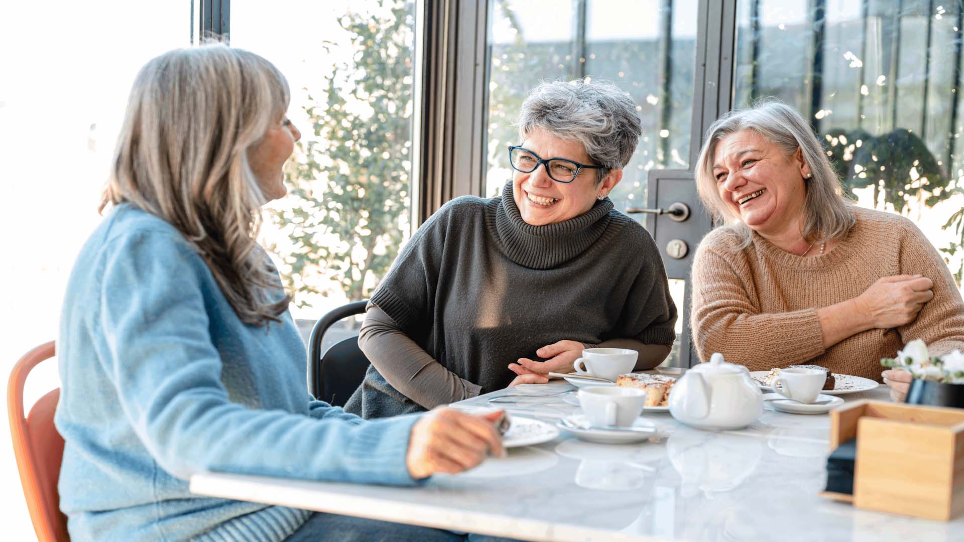 Three older ladies enjoying a pot of tea together