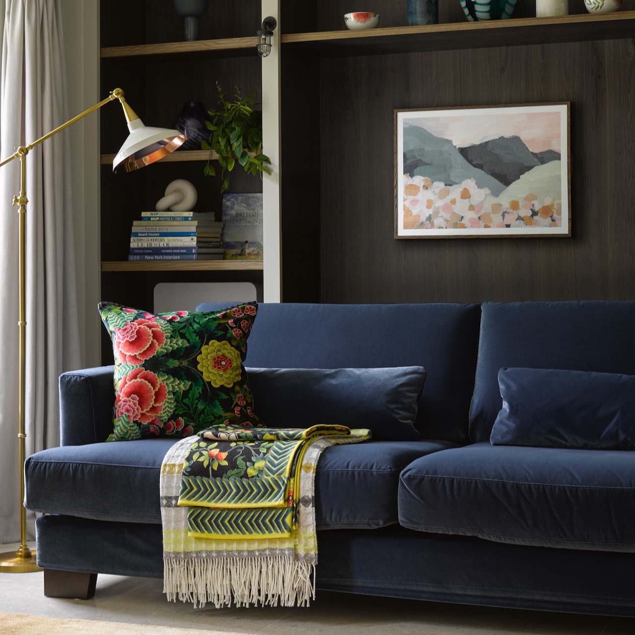 A blue sofa in a room decorated in dark tones