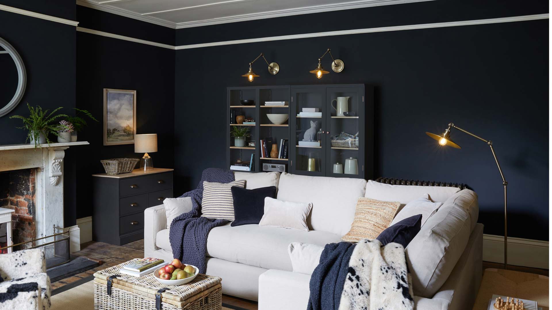 A room with dark blue walls and a cream sofa